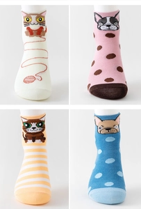 Detail of four pairs of cotton socks featuring cartoon cat and dog patterns in a grid layout