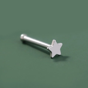 Detailed close-up of a silver stainless steel nose stud with a pentagram star design