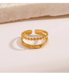 Detail of gold titanium steel double-layer ring with bead chain and twisted texture
