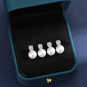 Macro detail of S925 silver wave earrings with freshwater pearls and cubic zirconia