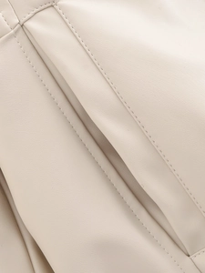 Close-up of beige leather jacket showing high-quality stitching and grain texture