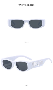Detail of white vintage sunglasses with silver palm letter decor and black lenses