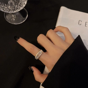 Detail of a luxury gold butterfly zircon ring worn by a model in a minimalist setting