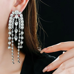 Close-up of sparkling silver chandelier crystal tassel earrings on a fashion model