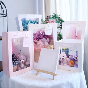 Multiple sizes of gift bags with PVC windows and decorative labels on velvet