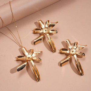 Detail view of the gold flower pendant necklace and matching earring jewelry set
