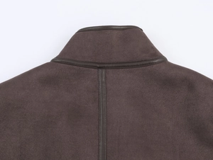 Close-up of suede jacket collar with faux leather trim and high-density stitching