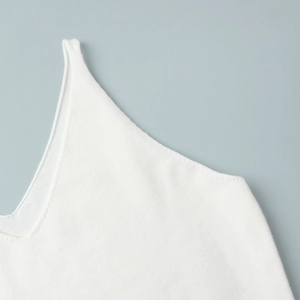 Close-up of soft white knitted tank top detail showing fine texture and smooth seams