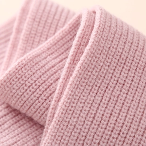 Detailed macro view of the pink ribbed knit texture of a warm winter scarf or sweater