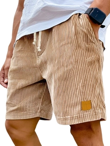 Detail of khaki corduroy texture and decorative leather patch on men's casual shorts