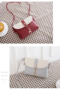 Detail showing two-tone mini crossbody bags in burgundy and grey with gold deer charms