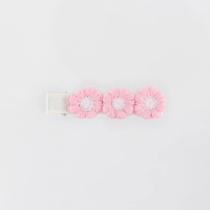 Close-up of three pink and white embroidered flowers on a sweet floral hair clip