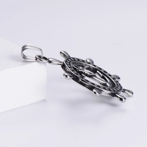 Vue macro du pendentif de gouvernail nautique en argent vieilli avec détails en relief