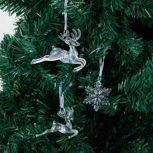Clear acrylic reindeer and snowflake ornaments hanging on a Christmas tree branch