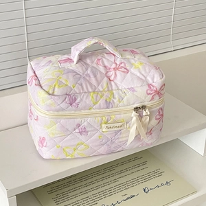 Quilted purple makeup bag with colorful butterfly patterns and stylish ribbon zipper