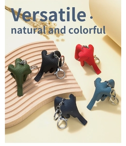 Detailed group shot of leather elephant keychains in five colors on a wooden prop