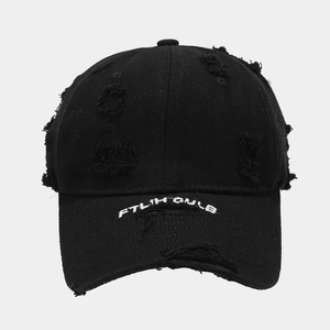 Close-up of distressed black cotton baseball cap with white FTLM GULB letter embroidery