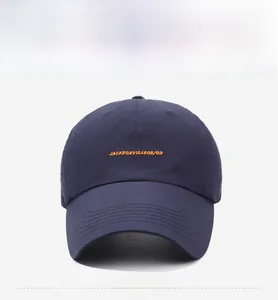 Vista detallada de gorra azul marino con bordado de letras amarillas y blancas