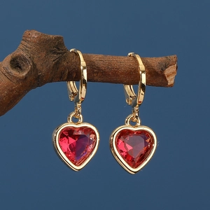 Élégantes boucles d'oreilles cœur dorées avec cristal rouge suspendues à une branche