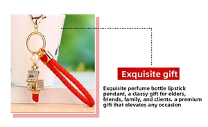 Close-up of red woven keychain with gold lipstick pendant and rhinestone inlay detail