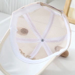 Close-up of beige kids baseball cap showing breathable white mesh lining and ears