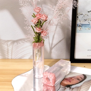 Detail of clear resin flower vases with pink crushed stone inlay and rose decor