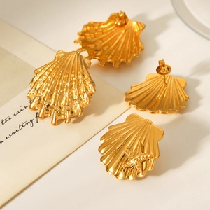 Macro detail of 18k gold plated stainless steel seashell and starfish earrings set