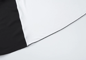 Détail rapproché montrant les coutures contrastées et la texture du tissu tissé lisse