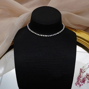 Close-up of sparkling rhinestone choker necklace on black velvet mannequin with satin