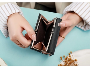 Detail showing internal compartments of short tri-fold wallet with rose gold metal clasp