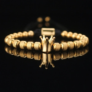 Macro view of golden crown bead with zircon inlay on a black woven adjustable bracelet