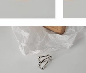 Close-up of minimalist S925 sterling silver irregular geometric ear cuff with wavy lines