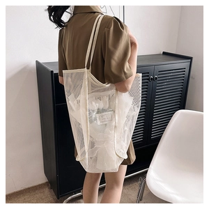 Vista dettagliata di una grande borsa tote in rete bianca con texture e capacità