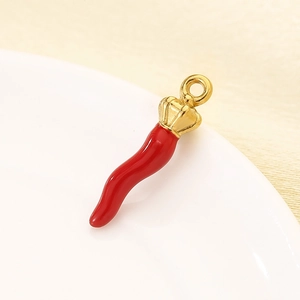 Detail of red chili pendant with golden crown made of stainless steel and enamel