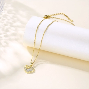 Collier en acier inoxydable 316L doré avec pendentif cœur et nœud sur support blanc