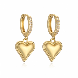 Macro detail of gold heart earrings featuring huggie hoop with sparkling zircon stones