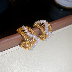 Close-up of C-shaped hollow earrings with 18k gold plating and white pearls