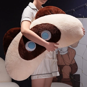 Cozy scene of a model holding a giant plush cat pillow with soft beige and brown fur