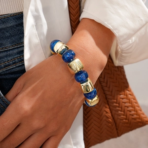 Close-up of geometric beaded bracelet with navy glitter beads and gold metal accents