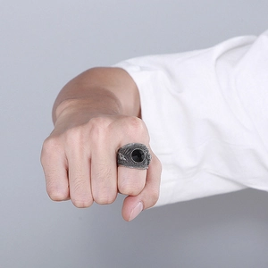 Dettaglio anello vintage da uomo in argento con pietra nera e intagli laterali