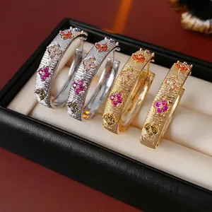 Boucles d'oreilles créoles fleurs en zircon plaqué or 18K avec texture brossée et gemmes