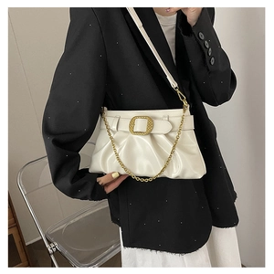 Détail du sac plissé blanc cassé avec boucle carrée dorée et chaîne métallique épaisse