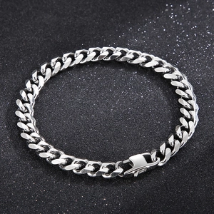 Detailed view of silver Cuban chain bracelet with metallic luster on dark textured background
