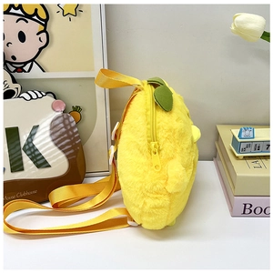 Side view of plush yellow fruit-shaped kids backpack with green leaf and zipper detail