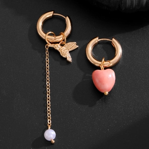 Asymmetric gold earrings with pink heart, hummingbird charm, and long pearl chain detail