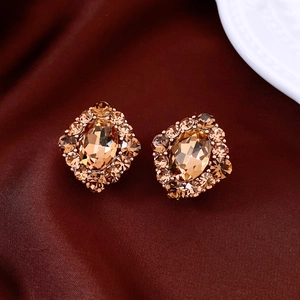 Macro di orecchini vintage in oro champagne con strass su seta rosso bordeaux