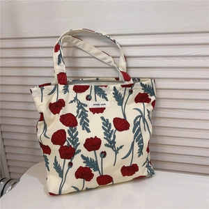 Detail of red poppy floral print on cotton bag with a simple wish woven label