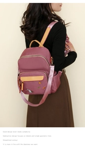 Close-up of pink backpack with cute rabbit and pumpkin embroidery and woven straps