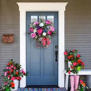 Hanging door flower basket with colorful peonies, roses and red ribbon on blue door