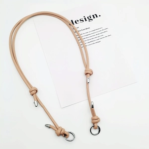 Detail eines rosa PU-Leder-Taschenriemens mit silbernen Metallschnallen und Knotendesign